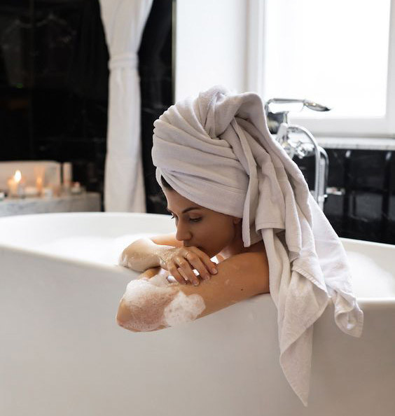 Девушка в ванной с полотенцем на голове